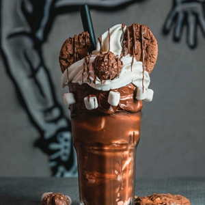 cookie dough milkshake topped with chocolate chip cookie